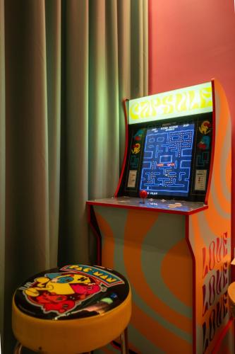 a room with a pinball machine and a stool at Capsule Flora business bay view Burj Khalifa-pool table-game arcade-Projector-Playstation 5 in Dubai