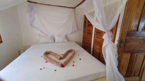 a bed with a heart made out of candy at Kirepwe Ecco Camp Watamu in Watamu