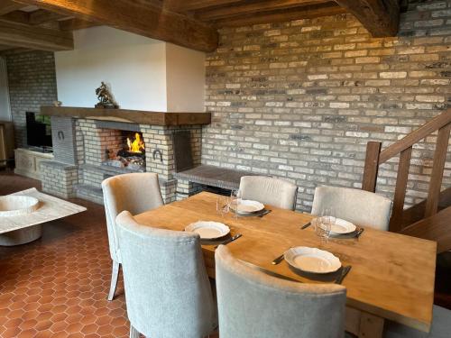une salle à manger avec une table et des chaises et une cheminée dans l'établissement Évasion Champêtre avec Jacuzzi Havre de Paix en Normandie, à Ancourt