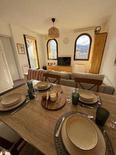 une salle à manger et un salon avec une table et des chaises dans l'établissement T3 expo sud, terrasse et vue montagne à Jausiers, à Jausiers