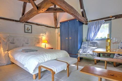 une chambre avec un lit, une chaise et une table dans l'établissement Sejour grand format, 23 couchages et grande piscine, à Saint-Laurent-des-Hommes