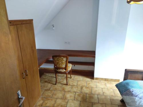 a bedroom with a chair and a bed in a room at Le Botcol in Plouguernével