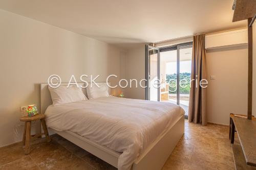 une chambre avec un lit et une fenêtre dans l'établissement Villa G, avec piscine et vue sur mer - La croix valmer, à La Croix-Valmer