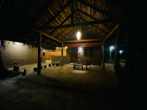 a pavilion with a table and a bench in the dark at Amuna Villa in Habarana
