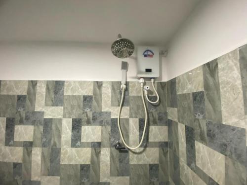 a shower in a bathroom with a mosaic tile floor at Amuna Villa in Habarana