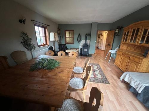 a living room with a wooden table and chairs at Ferienhaus Feldblick mit Kamin für 15 Personen in Rüdersdorf