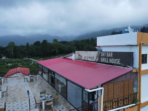 a building with a red roof with a view of a still house at Hotel 360 by D'Polo Dharamshala in Dharmsala