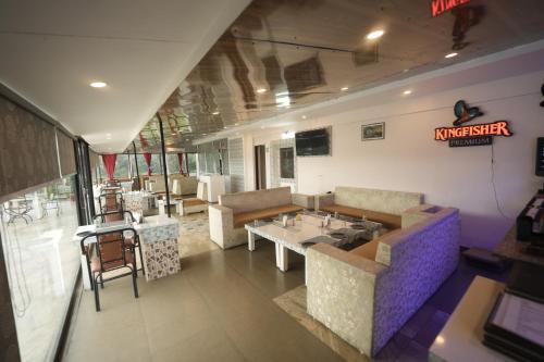 a restaurant with a table and chairs in a room at Hotel 360 by D'Polo Dharamshala in Dharmsala