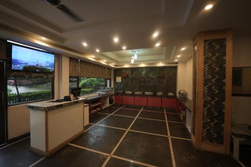 a kitchen with a counter and a large window at Hotel 360 by D'Polo Dharamshala in Dharmsala
