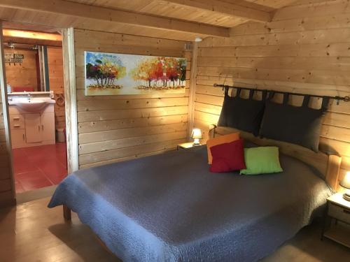 a bedroom with a bed in a wooden cabin at Le Mas de la Pinède in Bollène