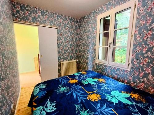 une chambre avec un lit avec une couette bleue dans l'établissement Maison Normande en lisière de la forêt, à Bernay