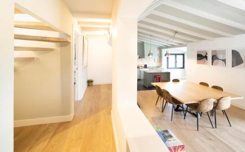 a dining room and kitchen with a wooden table and chairs at Casa Tajo in Miraflores de la Sierra