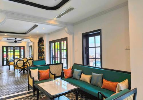 a living room with a green couch and a table at Yzistel Hoi An in Hoi An