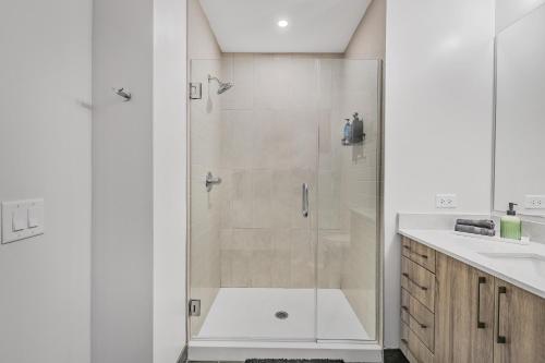 een witte badkamer met douche en wastafel bij Golden Luxe Suite Downtown Nashville in Nashville