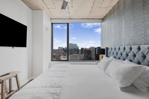 een slaapkamer met een groot bed met een groot raam bij Golden Luxe Suite Downtown Nashville in Nashville