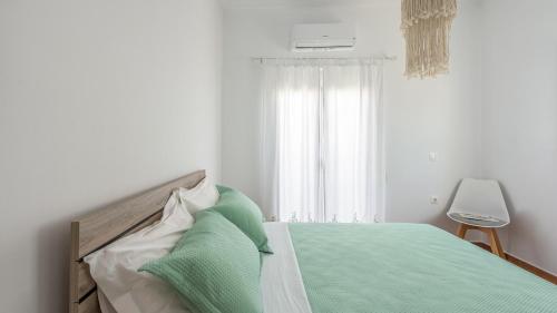 アダマスにあるVilla Ellania Milosのベッドルーム1室(緑のシーツが敷かれたベッド1台、窓付)