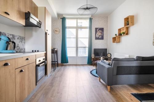 une cuisine et un salon avec un canapé dans l'établissement Le Vin Quatre - Studio proche Dordogne et parking privatif, à Bergerac