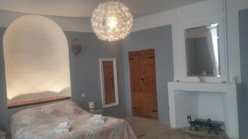 a bedroom with a bed and a chandelier at Le Temps d'un Rêve in Mazan