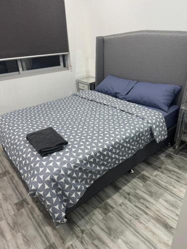 a bedroom with a bed with a black and white comforter at Cute Amazing Palace in Guildford