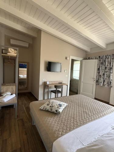 a bedroom with a bed and a desk and a tv at Masseria Spinale Wine Resort in Melfi