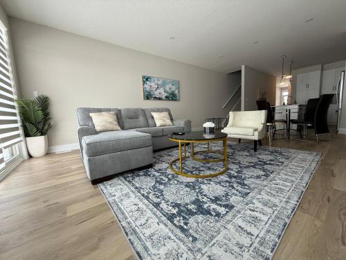 a living room with a couch and a table at Cozy 3 Bedroom Townhome Hyde Park Mall & Western University in London