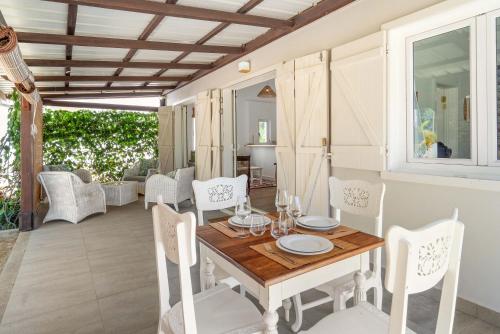 a dining room with a table and white chairs at Ti'Ocean Guest House - Incredible Beachfront Retreat in Grand Gaube
