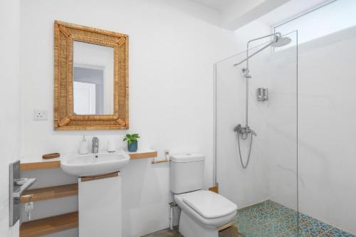 a bathroom with a toilet and a sink and a mirror at Ti'Ocean Guest House - Incredible Beachfront Retreat in Grand Gaube