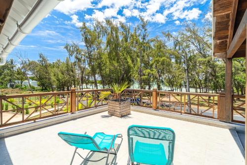 a deck with two chairs and a potted plant at Ti'Ocean Guest House - Incredible Beachfront Retreat in Grand Gaube