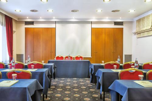 a conference room with blue tables and red chairs at Minerva Premier Hotel in Thessaloniki