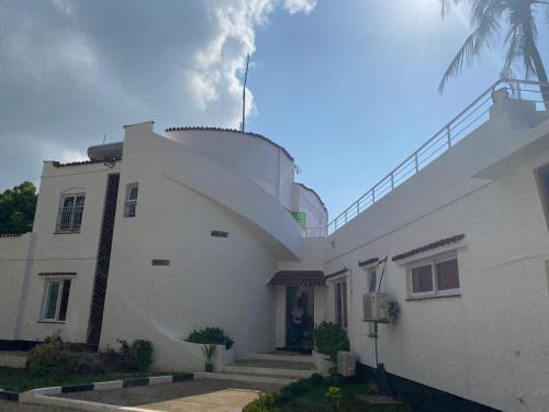 a white building with a tower on top of it at The Beach House by Maasai in Mombasa