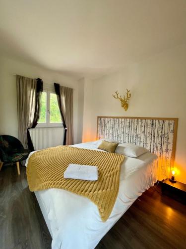 une chambre avec un grand lit avec une couverture jaune dans l'établissement Au bord de l'eau, à Tendu