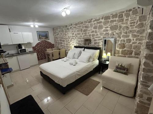 a bedroom with a bed and a stone wall at Antea in Split