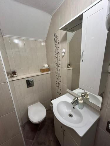 a bathroom with a sink and a toilet and a mirror at Antea in Split