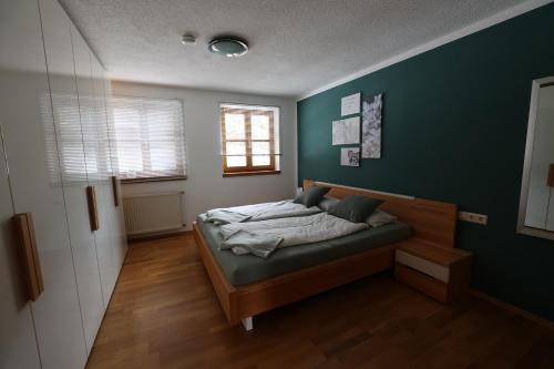 a bedroom with a bed with a green wall at Gemütliche Auszeit zu Zweit im Rothauser Land in Grafenhausen