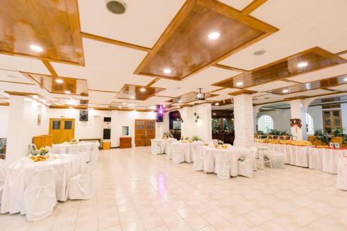 a large banquet hall with white tables and chairs at HAUS MALIBU Guesthouse & Restaurant in Malaybalay