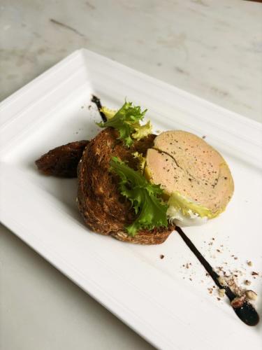 a sandwich on a white plate on a table at Hostellerie Du Lys in Lamorlaye