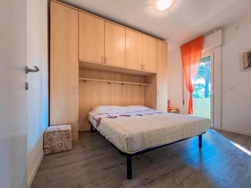 a bedroom with a bed and cabinets and a window at Pace in Bibione