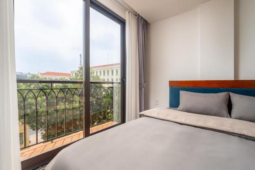 a bedroom with a bed and a large window at Evelyn Indochine Chic in Central Hanoi in Hanoi