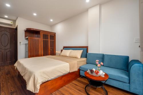 a bedroom with a bed and a blue couch at Evelyn Indochine Chic in Central Hanoi in Hanoi