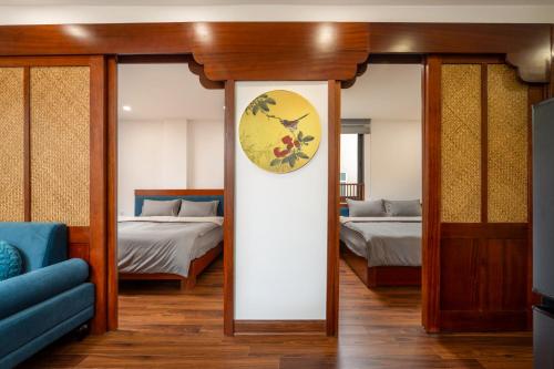 a room with two beds and a clock on the wall at Evelyn Indochine Chic in Central Hanoi in Hanoi