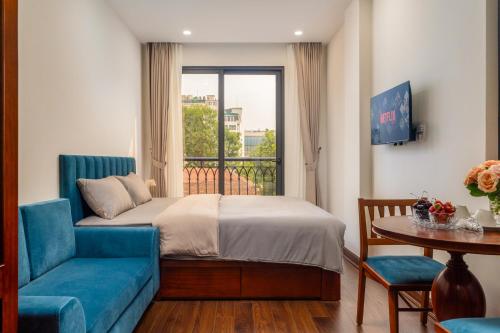 a bedroom with a bed and a blue couch and a window at Evelyn Indochine Chic in Central Hanoi in Hanoi