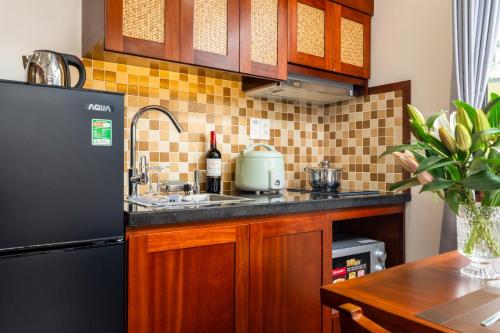 a kitchen with a black refrigerator and a sink at Evelyn Indochine Chic in Central Hanoi in Hanoi