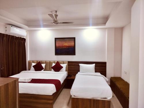 a hotel room with two beds and a ceiling at Divine Homestay in Siliguri