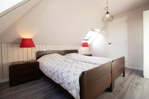 a bedroom with a bed and two red lamps at Luxurious and spacious apartment in historic building in Vianen
