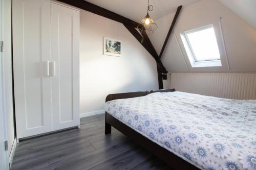 a bedroom with a bed and a window at Luxurious and spacious apartment in historic building in Vianen