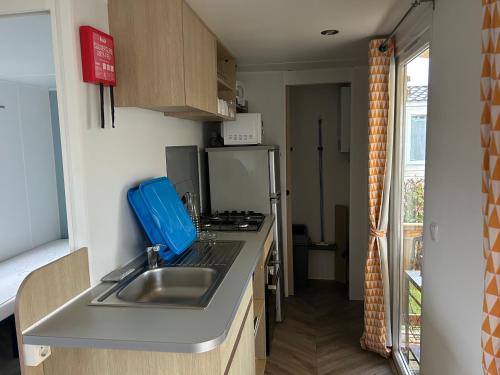 a small kitchen with a sink and a refrigerator at mobil-home de 4 à 6 personnes in Onzain