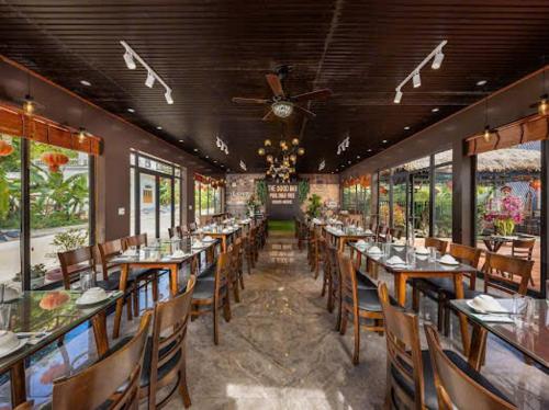 a dining room with tables and chairs in a restaurant at Aroma Viet Hai Village Homestay in Khê Bao