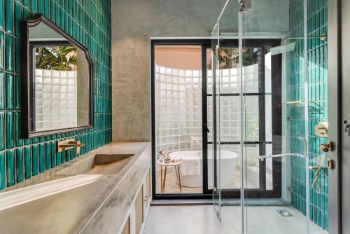 a bathroom with a tub and a shower with green tiles at Wadi House - Lux 3BR Villa in Siolim, 4km to beach in Siolim