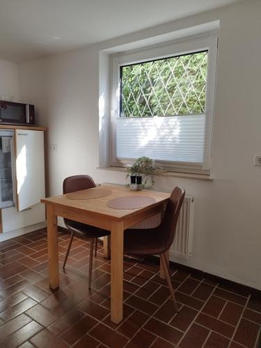 a table and two chairs in a room with a window at Moderne Ferienwohnung mit privatem Eingang - ROSA in Kalletal