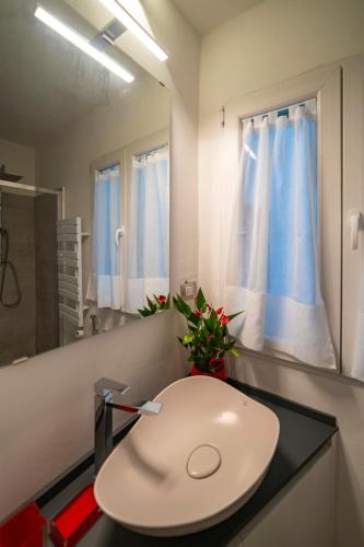 a bathroom with a white sink and a mirror at MagentA NesT - Loft&Charme in Brescia